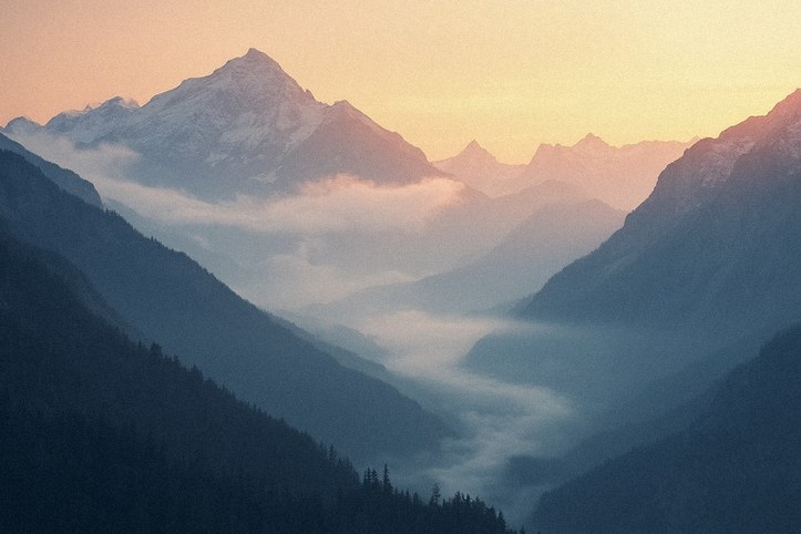 Fotografía de un paisaje montañoso con niebla al amanecer